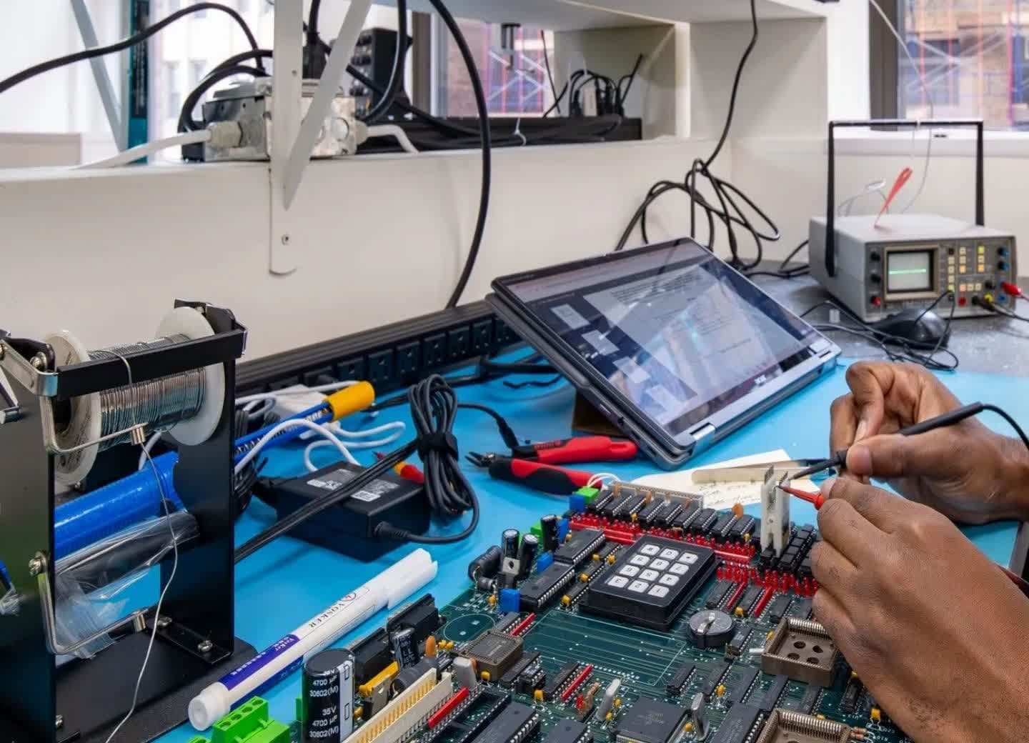 Elevator PCB repair technician using diagnostic techniques to test elevator boards